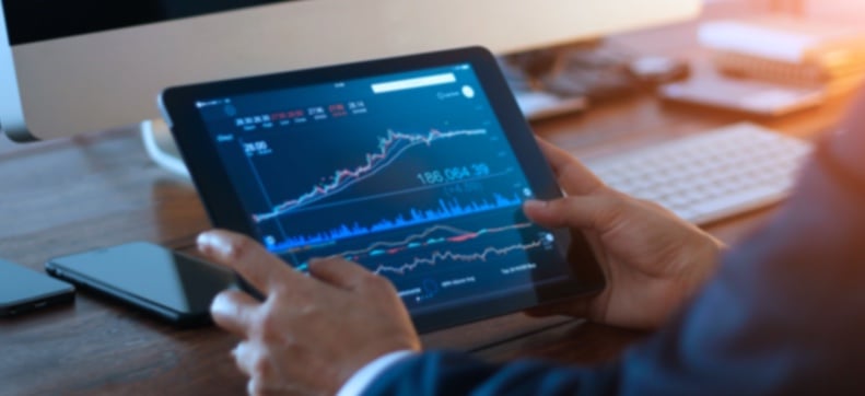 Man looking at graphs on tablet