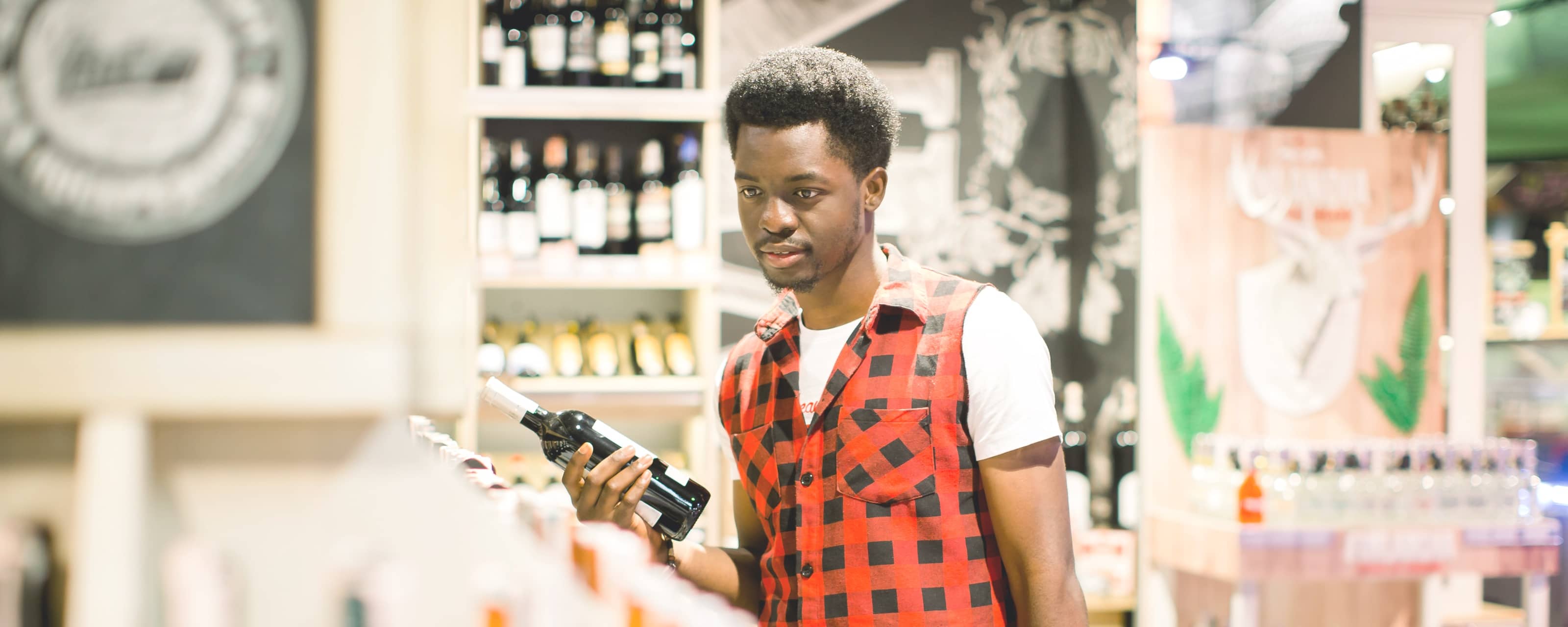Young shopper comparing wines
