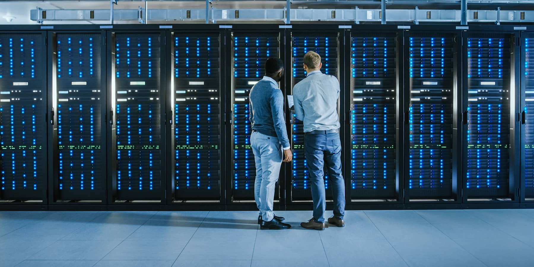 Two people examining a server rack
